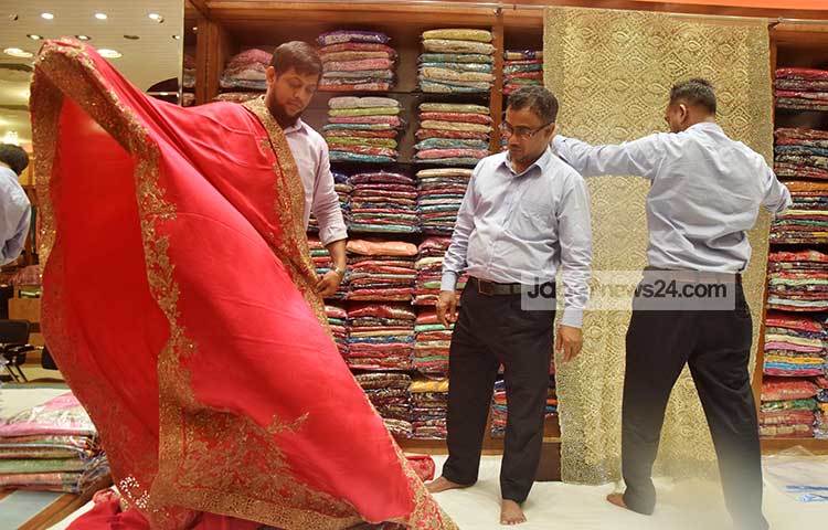 ক্রেতাদের শাড়ি দেখাতে ব্যস্ত দোকানীরা। বসুন্ধরা সিটির এসব দোকানে দেশি বিদেশি শাড়ি আনা হয়েছে। ছবি : মাহবুব আলম