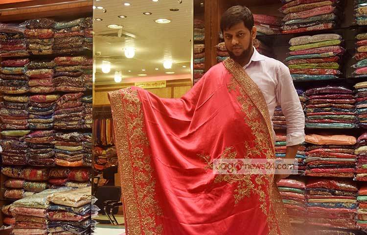 ক্রেতাদের মনোযোগ আকর্ষণ করার জন্য এই বিক্রেতা শাড়ি মেলে দেখাচ্ছেন। ছবি : মাহবুব আলম