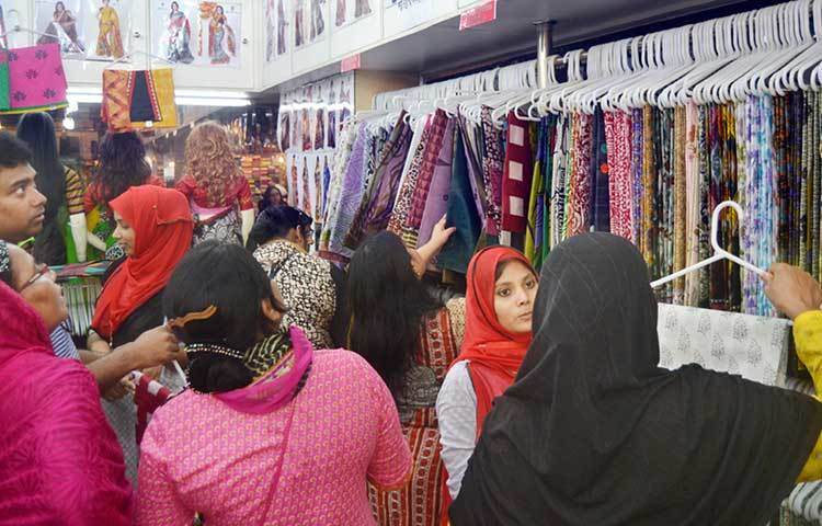 পছন্দের শাড়ি বাছাইয়ে ব্যস্ত এই ক্রেতারা। শাড়ির দোকানে উপচে পড়া ভিড়। ছবি : বিপ্লব দিক্ষিৎ