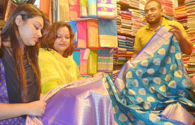 মেয়ে ক্রেতাদের মধ্যে বেশিরভাগই শাড়ি পছন্দ করছেন। ক্রেতারা দোকান ঘুরে ঘুরে তাদের পোশাক কিনছেন। ছবি : বিপ্লব দিক্ষিৎ