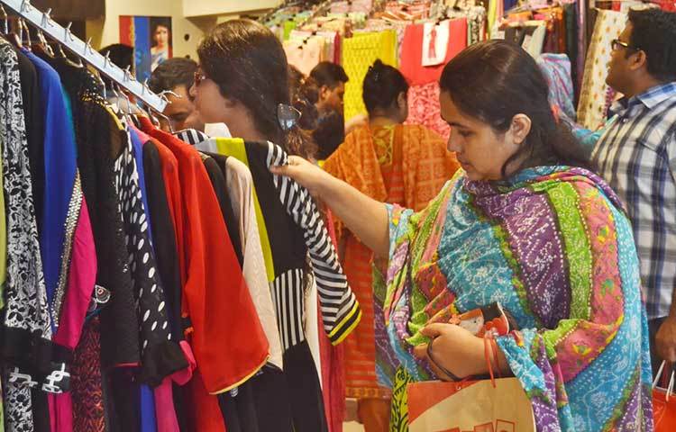 পরিবারের সব সদস্যদের জন্য পছন্দ করে পোশাক কিনছেন এই নারী। ছবি : বিপ্লব দিক্ষিৎ