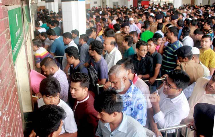 দীর্ঘ কয়েক ঘণ্টা লাইনে দাঁড়ানো এসব মানুষের ভোগান্তি-বিড়ম্বনার যেন শেষ নেই। তবুও লাইন ছেড়ে যেতে নারাজ তারা। ছবি : বিপ্লব দিক্ষিৎ