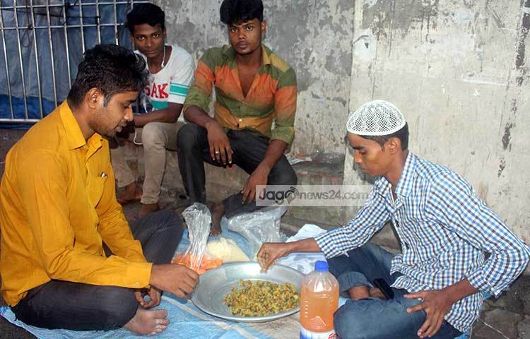 রাস্তার ফুটপাথে বসে ইফতার করছেন শ্রমজীবী মানুষ। এভাবেই তারা প্রতিদিন ইফতার করছেন। ছবি : বিপ্লব দিক্ষিৎ