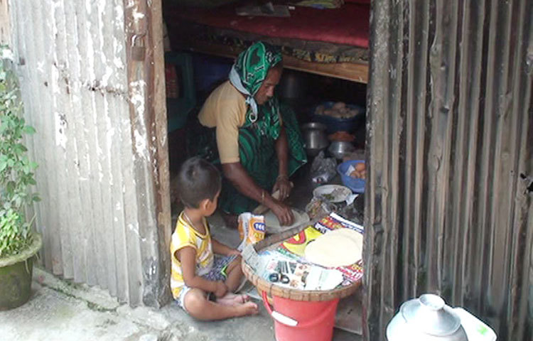 রুটি তৈরির কাজে ব্যস্ত যৌনপল্লির এই বৃদ্ধা। সকাল সন্ধ্যা তাকে নানা ধরনের কাজে ব্যস্ত থাকতে হয়। ছবি : শুভ্র মেহেদী