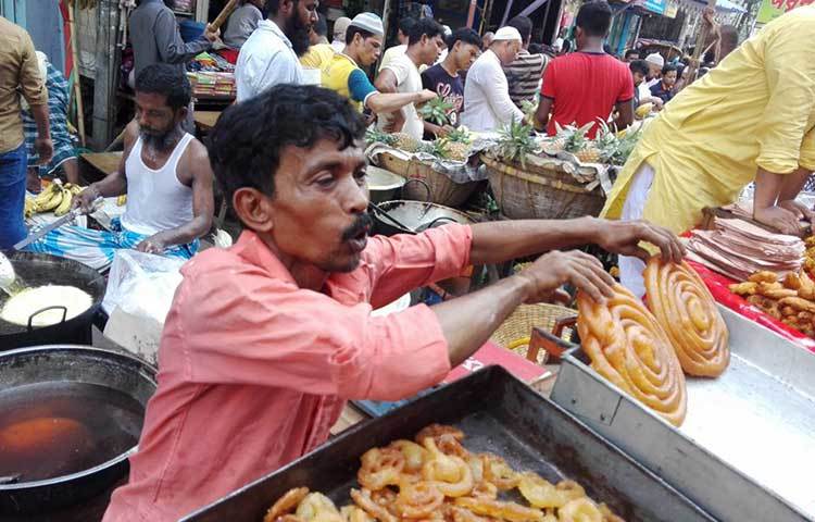 ক্রেতাদের আকর্ষণ করার জন্য এই বিক্রেতা তার বাদশাহী জিলাপি সাজিয়ে রাখছেন। ছবি : আবু সালেহ সায়াদাত