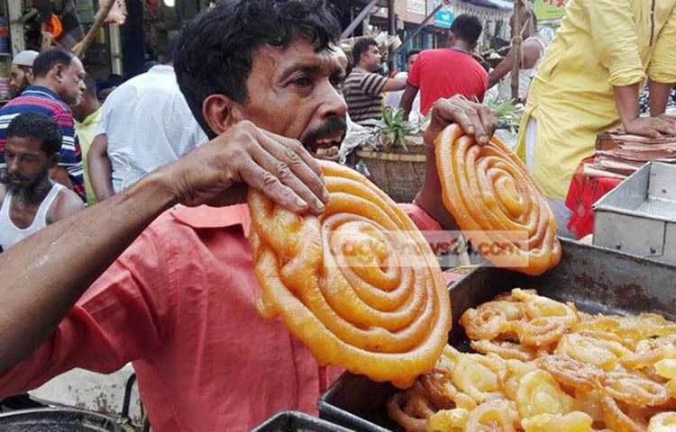 ক্রেতাদের বাদশাহী জিলাপি দেখাতে ব্যস্ত এই বিক্রেতা। প্রতিবছরের মতো এবারও চকবাজারে নানা নকশার বাদশাহী জিলাপি নিয়ে বসেছেন বিক্রেতারা। ছবি : আবু সালেহ সায়াদাত