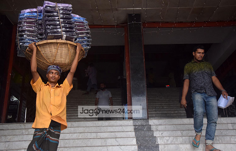 কারখানা থেকে শো-রুমে ঈদের পোশাক নিয়ে যাচেছন এই শ্রমিক। ছবি : মাহবুব আলম