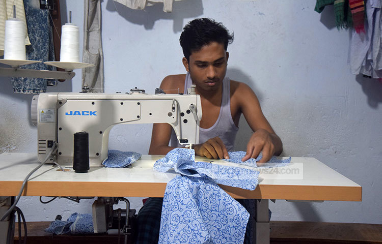 পোশাক সেলাইয়ের কাজে ব্যস্ত এই পোশাক শ্রমিক। ঈদের পোশাক তৈরির কাজে তার যেন দম ফেলার সময় নেই।ছবি : মাহবুব আলম