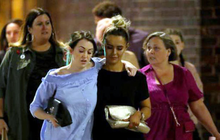 আহত এক নারীকে চিকিৎসার জন্য নিয়ে যাওয়া হচ্ছে।