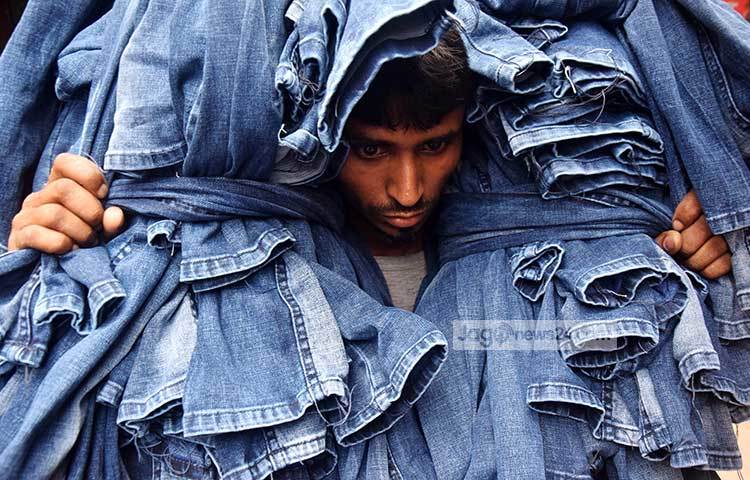 প্যান্টের বিশাল বোঝা মাথায় নিয়ে যাচ্ছেন একজন শ্রমিক। ছবি : মাহবুব আলম