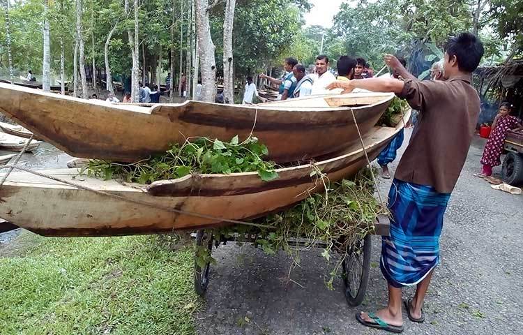 ভ্যান গাড়িতে করে নৌকা কিনে নিয়ে যাচ্ছেন ক্রেতারা। আধুনিক সভ্যতায় যন্ত্রচালিত জলযানের রাজত্ব থাকলেও এখানকার মানুষের কাছে নৌকার কদর শত শত বছর ধরে। ছবি : হাসান মামুন