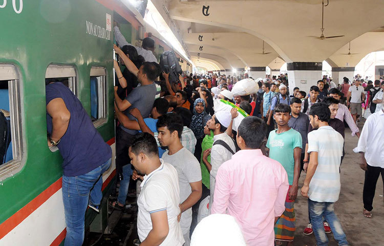 ট্রেনে ওঠার যুদ্ধ। যে করেই হোক ট্রেনে উঠতে হবে। নাড়ির টানে বাড়ি ফেরার কাছে কোনো বাধাই বাধা নয়। ছবি : বিপ্লব দিক্ষিৎ