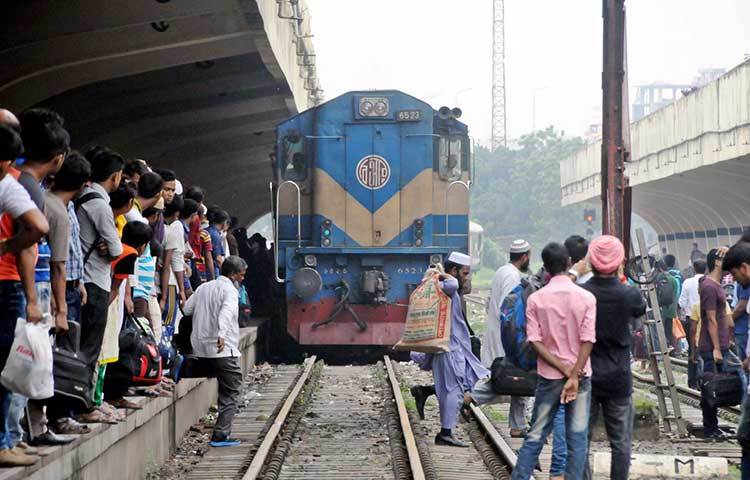 যাত্রী নিয়ে ছুটছে ট্রেন। পরের ট্রেন আসার অপেক্ষায় দাঁড়িয়ে আছেন যাত্রীরা। ছবি : বিপ্লব দিক্ষিৎ
