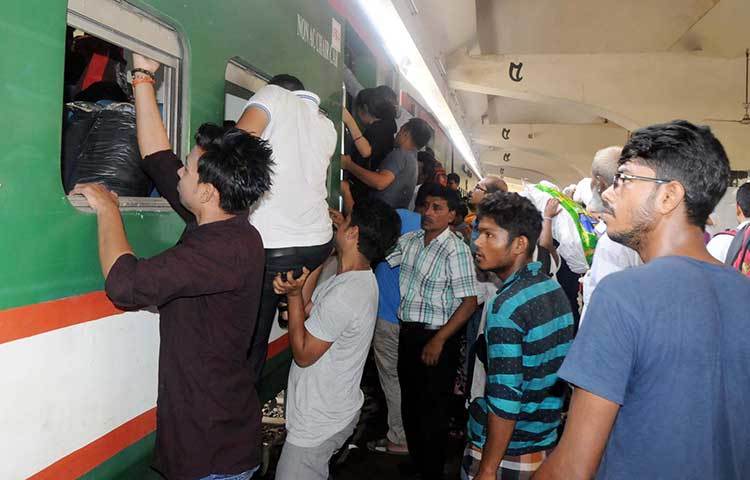 ট্রেনের জানালা দিয়ে উঠছেন কেউ কেউ। এভাবে ট্রেনে ওঠা ঝুঁকিপূর্ণ জেনেও অনেকেই জানালা দিয়ে ট্রেনে উঠছেন। ছবি : বিপ্লব দিক্ষিৎ