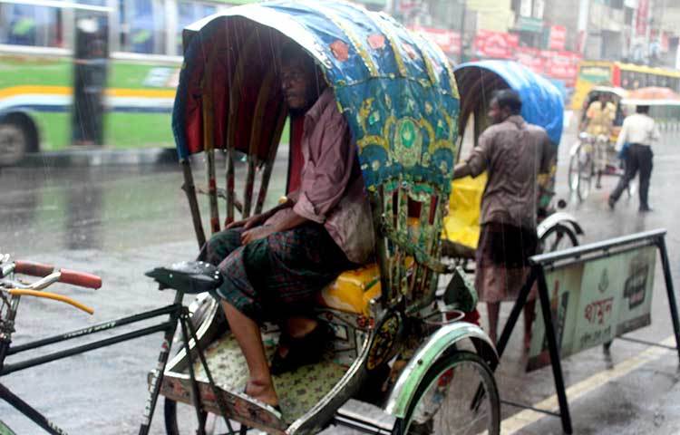 বৃষ্টির কারণে রিকশা থামিয়ে বসে আছেন রিকশাওয়ালারা। কয়েকদিনের দুঃসহ গরম থেকে তারা একটু নিস্তার পেয়েছেন। ছবি : বিপ্লব দিক্ষিৎ
