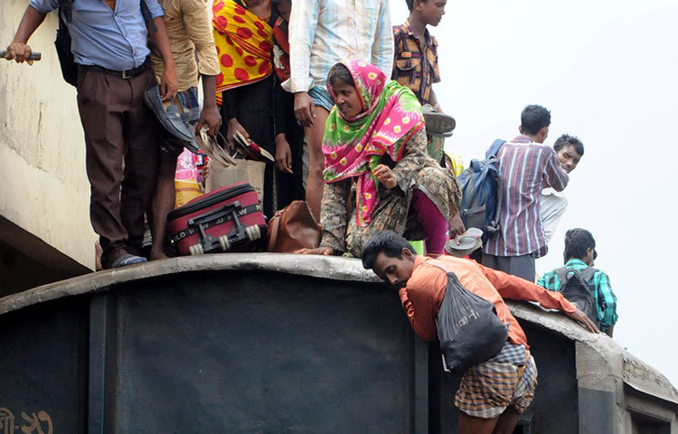 ট্রেনের ভেতরে জায়গা না পাওয়ায় ছাদে উঠেছিলো এই সব যাত্রী। জীবনের ঝুঁকি নিয়ে তারা গ্রাম থেকে শহরে আসছে। ছবি : বিপ্লব দিক্ষিৎ