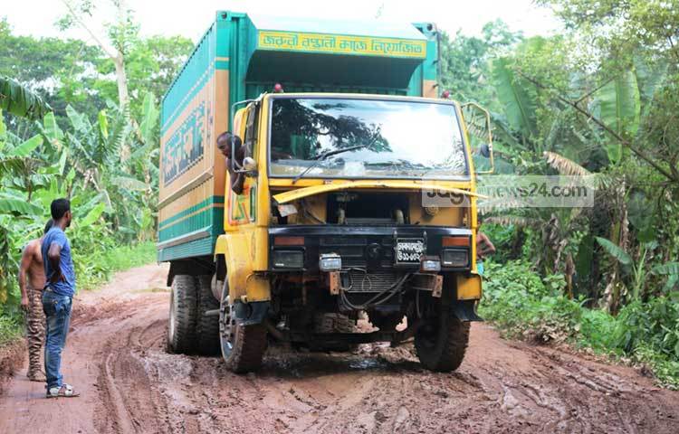 কাদায় আটকা পড়েছে মালবাহী ট্রাক। যাতায়াতের একমাত্র জনগুরুত্বপূর্ণ এই আঞ্চলিক সড়কটি তড়িঘড়ি করে পিচের উপর ইটের সলিং করে দায়সারাভাবে চলে। ছবি : মো. ছগির হোসেন
