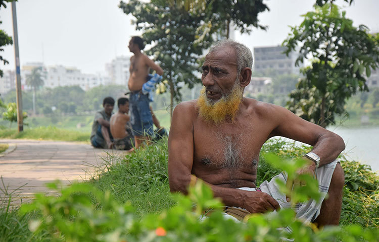 গরমে একটু বাতাসের পরশ পেতে হাতিরঝিলের উন্মুক্ত স্থানে বসে আছেন এই প্রবীণ মানুষটি। ছবি : মাহবুব আলম