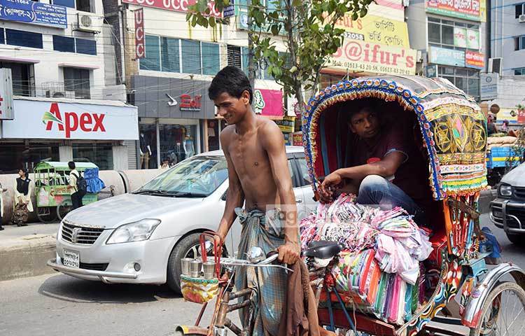 প্রচণ্ড রোদ আর গরমের যন্ত্রণায় গায়ের জামা খুলে গরম থেকে বাঁচতে চাইছেন রিকশাওয়ালা। ছবি : মাহবুব আলম