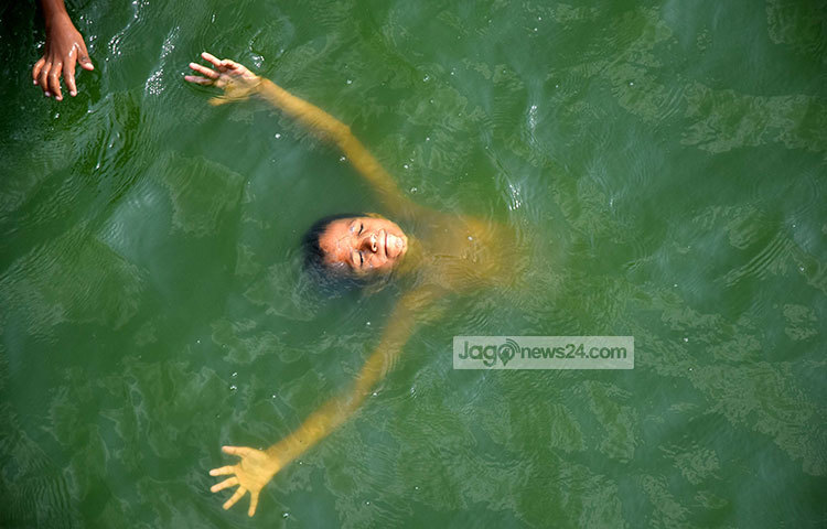 গরম থেকে বাচঁতে ডুব-সাঁতার খেলেছে শিশুটি। ছবি : মাহবুব আলম