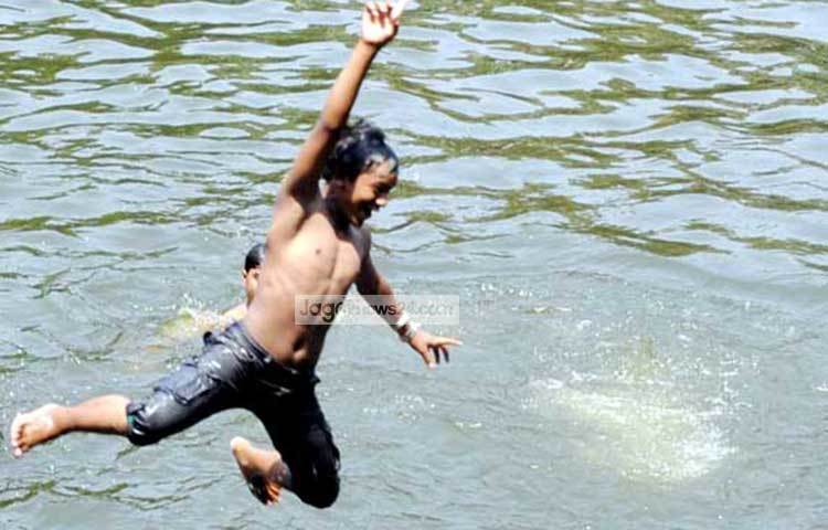 উচ্ছ্বাসে পানিতে ঝাপ দিচ্ছে এক কিশোর। গরমের হাত থেকে বাঁচার জন্য এ যেন এক লড়াই। ছবি : বিপ্লব দিক্ষিৎ