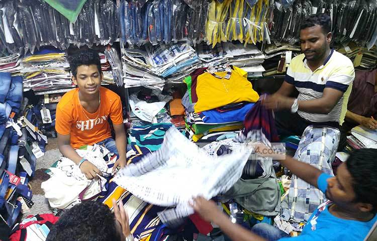 ঈদের পোশাক বিক্রির কাজে নিয়োজিত (মাঝে) এক শিশু। সকাল সন্ধ্যা তাকে এই কাজে ব্যস্ত থাকতে হয়। ছবি : মাহবুব আলম