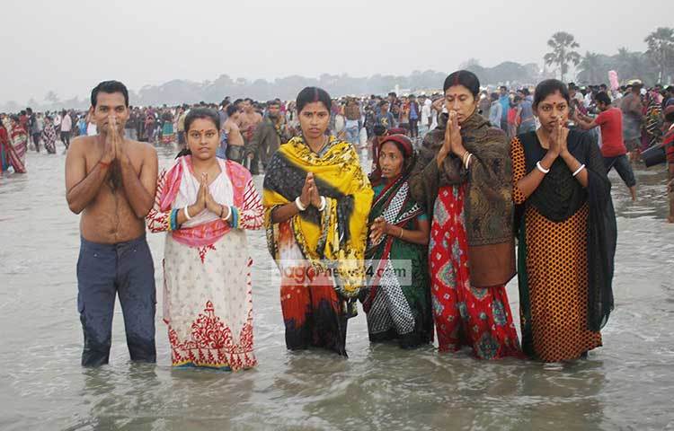 বঙ্গোপসাগরের লোনা জলে নেমেছে হিন্দু সম্প্রদায়ের হাজারো নর-নারী। ছবি : কাজী সাঈদ