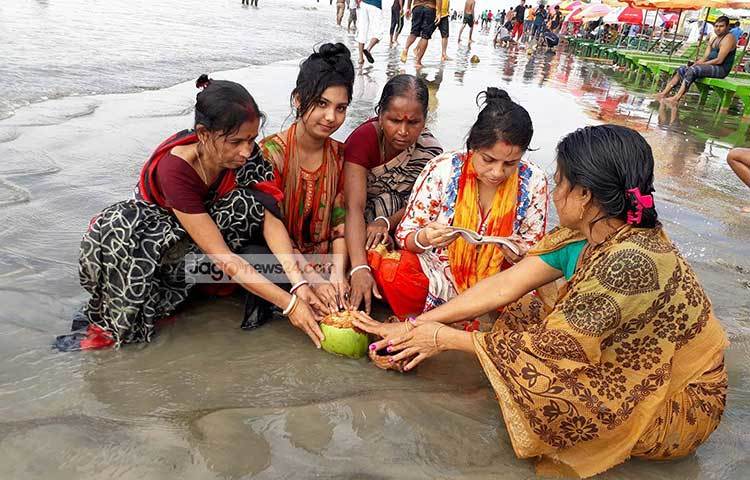 পূণ্যার্থীরা পূর্ণিমার মধ্যে উলুধ্বনি ও মন্ত্রপাঠ করে গঙ্গাস্নানের মধ্য দিয়ে শেষ করেছেন এবছরের রাসমেলা। ছবি : কাজী সাঈদ