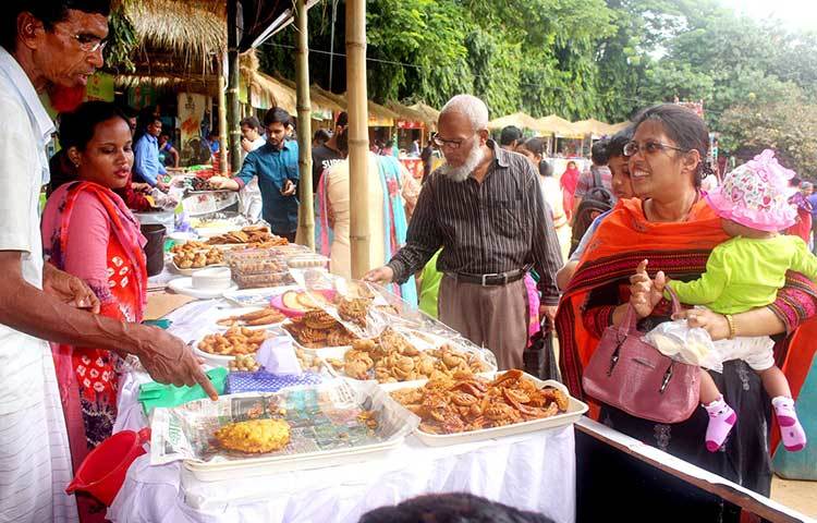 উৎসবে আগতরা বিভিন্ন ধরনের পিঠা দেখছেন। প্রাণ চিনিগুড়া-সুগন্ধি চালের আয়োজনে মেলা চলছে। ছবি : বিপ্লব দিক্ষৎ