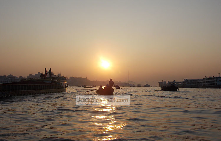 সূর্যোদয়ের সঙ্গে পাল্লা দিয়ে ছুটছে বালুবাহী কার্গো। বুুড়িগঙ্গার কালোজলে ভোরের আলো পড়ে চকচক করছে। ছবি : রবিউল ইসলাম পলাশ