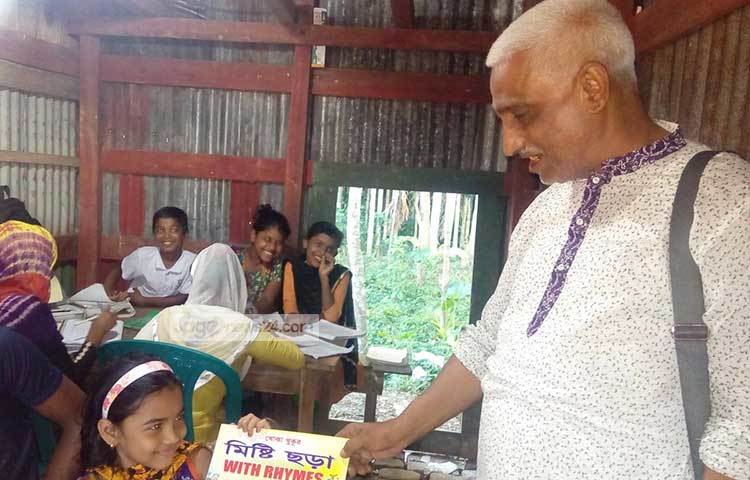 শিশুটির হাতে ছড়ার বই তুলে দিচ্ছেন আলোর পথযাত্রী খসরু। ছবি : হাসান মামুন