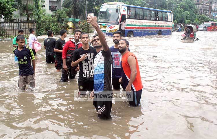 রাস্তা ডুবে সমুদ্র সৈকতের মত হয়ে গেছে। আনন্দে সবাই ফেসফি তোলায় মেতেছে! ছবি : বিপ্লব দিক্ষিৎ