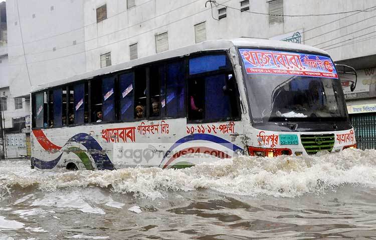 বিশাল জলরাশি ঢেলে চলছে বাস। বাস যেন জলযানে রূপ নিয়েছে। ছবি : বিপ্লব দিক্ষিৎ