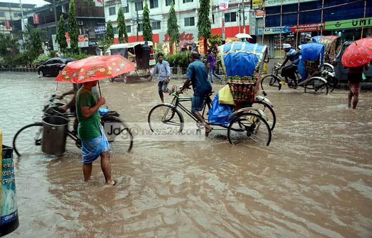 রাস্তা ডুবে নদীর মত হয়ে গেছে। বৃষ্টির কারণে রাস্তাঘাটে যানবাহনের সংখ্যা খুবই কম। ছবি : বিপ্লব দিক্ষিৎ