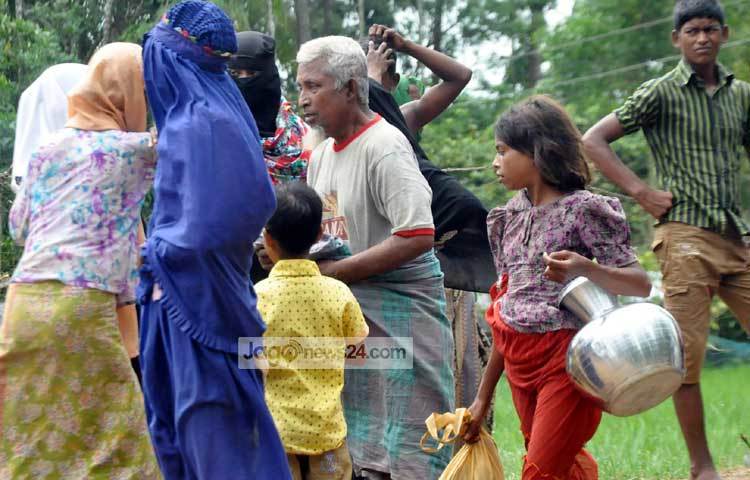 পানি সংগ্রহে ছুটছে এ রোহিঙ্গা শিশু। অন্যদিকে ত্রাণ পেয়ে তা ভাগাভাগি করে নিচ্ছেন রোহিঙ্গারা। ছবি : বিপ্লব দিক্ষিৎ