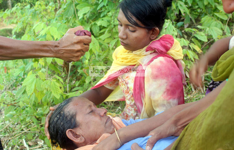 হঠাৎ অজ্ঞান হয়ে পড়া এই রোহিঙ্গা নারীকে স্বজনরা মাথায় পানি দিয়ে সুস্থ করে তোলার চেষ্টা করছেন। ছবি : বিপ্লব দিক্ষিৎ
