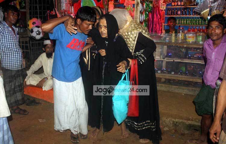 হাঁটতে পারছেন না এই রোহিঙ্গা বৃদ্ধা। স্বজনদের কাঁধে ভর করে পথ চলার চেষ্টা করছেন। ছবি : বিপ্লব দিক্ষিৎ