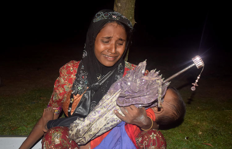 মাতৃভূমি থেকে বিতাড়িত হওয়ার চেয়ে বড় বেদনার আর কী হতে পারে! তাইতো এ রোহিঙ্গা নারী কোলে শিশু সন্তান নিয়ে অঝোরে কাঁদছেন। ছবি : মাহবুব আলম
