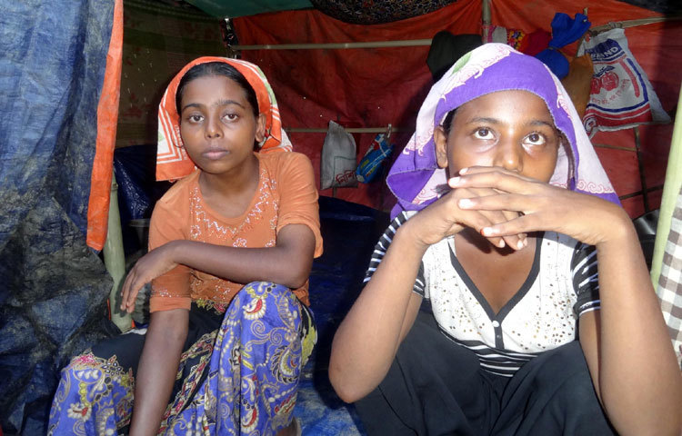 উদাস দৃষ্টিতে তাকিয়ে আছে দুই রোহিঙ্গা কিশোরী। জন্মভূমির সব কিছু হারিয়ে আজ বাংলাদেশে তারা পরবাসিনী। ছবি : বিপ্লব দিক্ষিৎ