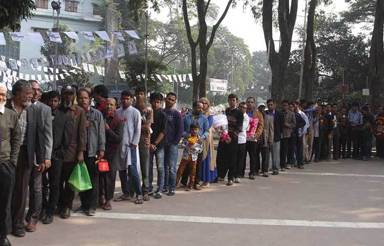 সদ্যপ্রয়াত আমজাদ হোসেনের ভক্ত-অনুরাগীরা লাইনে দাঁড়িয়ে ফুলেল শ্রদ্ধা জানান। ছবি : মাহবুব আলম