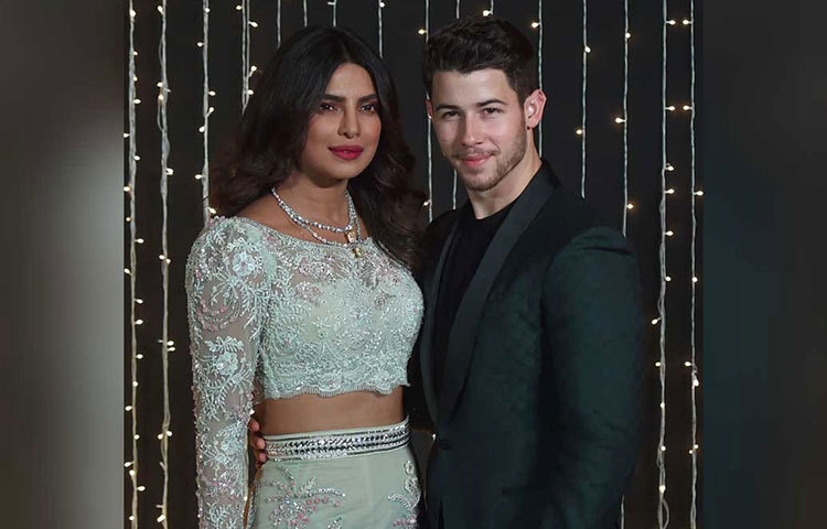 নিক ও প্রিয়াঙ্কা দু’জনেরই রিসেপশনের সাজ ছিল চোখ ধাঁধানো! সাদা শিফনের স্কার্টের উপর লেস, সুতো ও জরির কাজ ও একই নকশার টপে প্রিয়াঙ্কা হয়ে উঠেছিলেন অনন্যা। উল্টো দিকে জমকালো ব্লু শেডেড স্যুটের নিকের দিক থেকেও চোখ ফেরানো দায় হয়ে উঠেছিল।