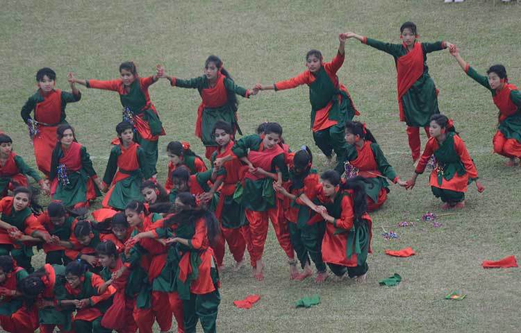 লাল সবুজের পোশাকে নৃত্য করছে শিক্ষার্থীরা। ছবি : মিনহাজ উদ্দিন