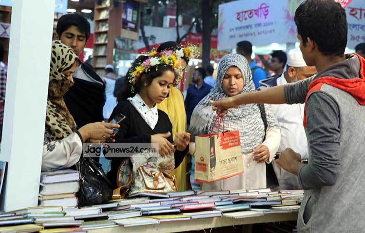 পাঠকের হাতে বই তুলে দিচ্ছেন বিক্রেতা। ছবি : বিপ্লব দিক্ষিৎ