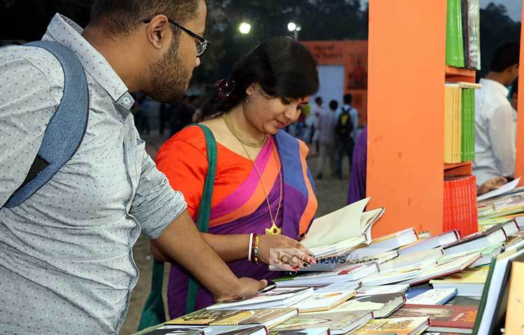 বই কেনার আগে পাতায় চোখ বুলিয়ে নিচ্ছেন এই পাঠক। পছন্দের বইটি হয়তো তিনি খুঁজে পেয়েছেন। ছবি : বিপ্লব দিক্ষিৎ