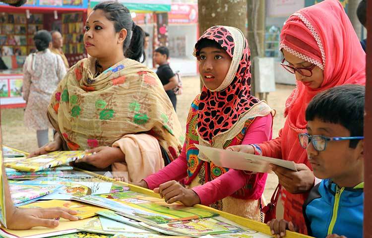 একটি শিশুতোষ বইয়ের স্টলে পছন্দের বই খুঁজছেন পাঠক। ছবি : বিপ্লব দিক্ষিৎ