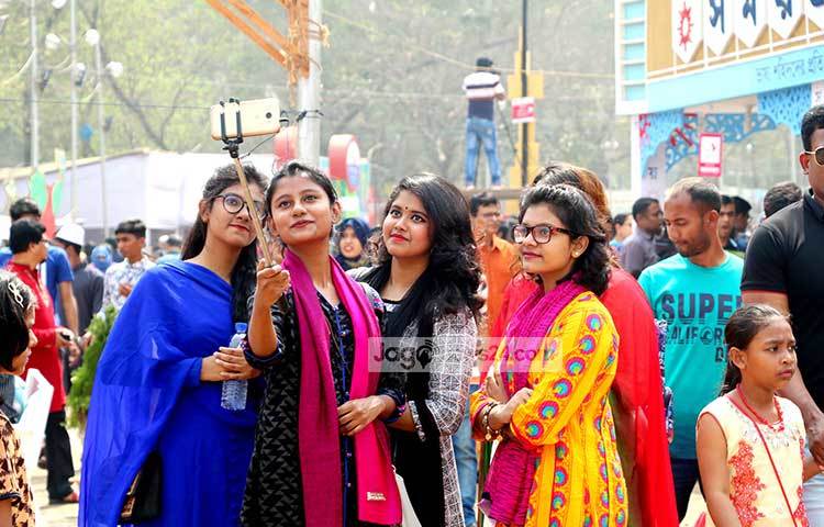 বইমেলায় আসা তরুণীরা সেলফি তোলায় ব্যস্ত। ছবি : বিপ্লব দিক্ষিৎ