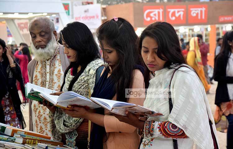 বইয়ের পাতা উল্টে-পাল্টে দেখছেন পাঠক। মেলার এমন দৃশ্য সত্যিই মনোরম। ছবি : মাহবুব আলম
