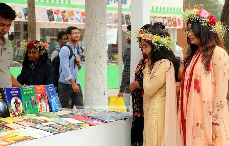 মেলার মাঠে বই কিনতে এসে মাথায় ফুল দিয়ে সেজেছেন তরুণীরা। ছবি : বিপ্লব দিক্ষিৎ