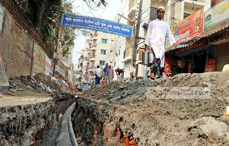 রাস্তা খুঁড়ে খালের মতো করা হয়ছে। এতে পথচারীদের চলাচলে বিঘ্ন ঘটছে। ছবি : বিপ্লব দিক্ষিৎ