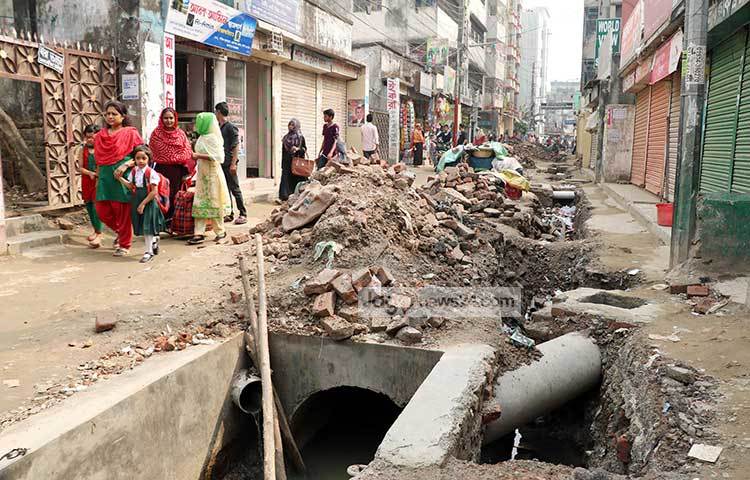 এ রাস্তার কাজ চলছে খুবই ধীর গতিতে। রাস্তার উপর মাটির স্তূপ থাকায় কোনো যানবাহন চলালচল করতে পারছে না। ফলে হেঁটে সবাইকে গন্তব্যে যেতে হচ্ছে। ছবি : বিপ্লব দিক্ষিৎ